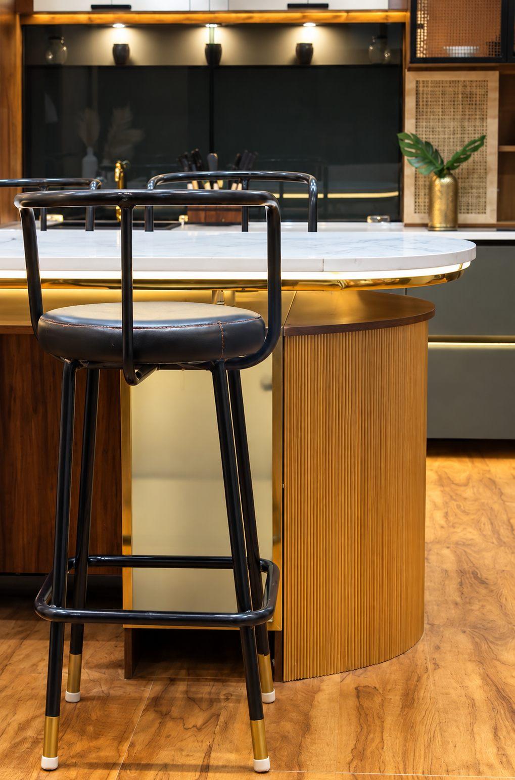 Bar counter with a curved wooden base, stone top and black stools in Willow’s display studio