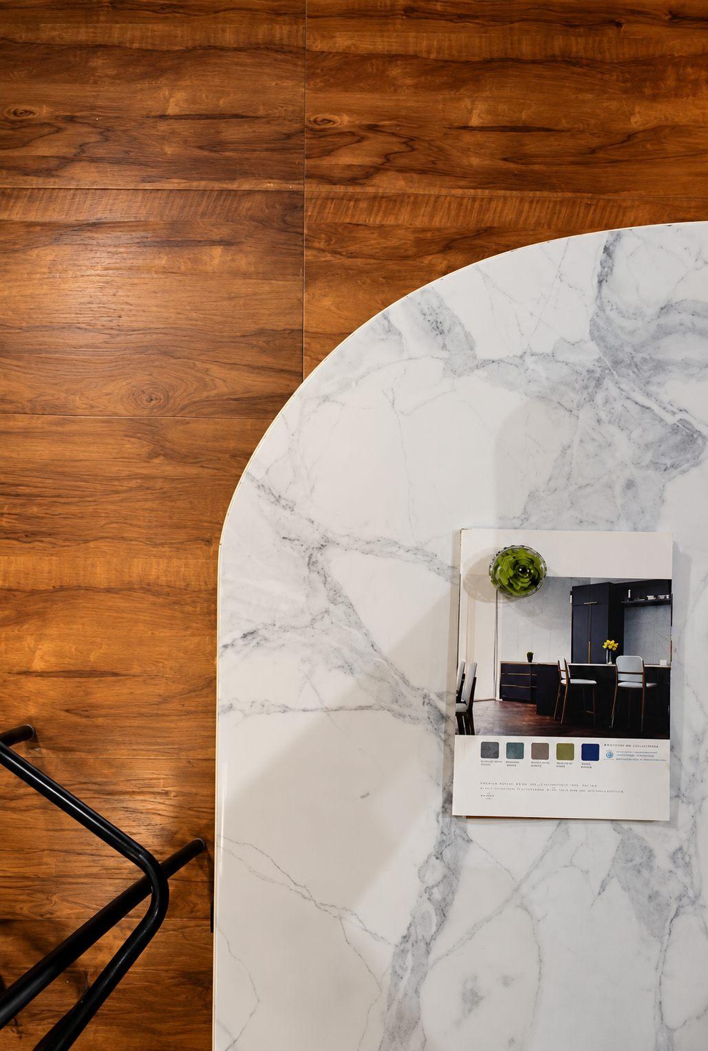 Marble-finish laminate arch panel beside a wood-grain wall, with a material sample board showing finish options