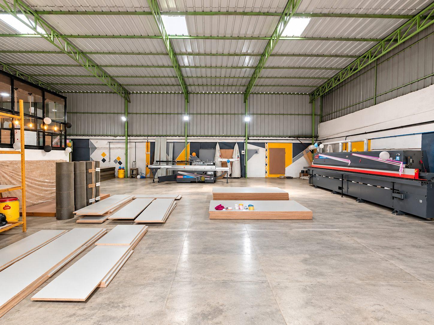 Factory floor of Willow’s modular furniture manufacturing unit in JP Nagar, Bangalore, with panels laid out and an edge banding line