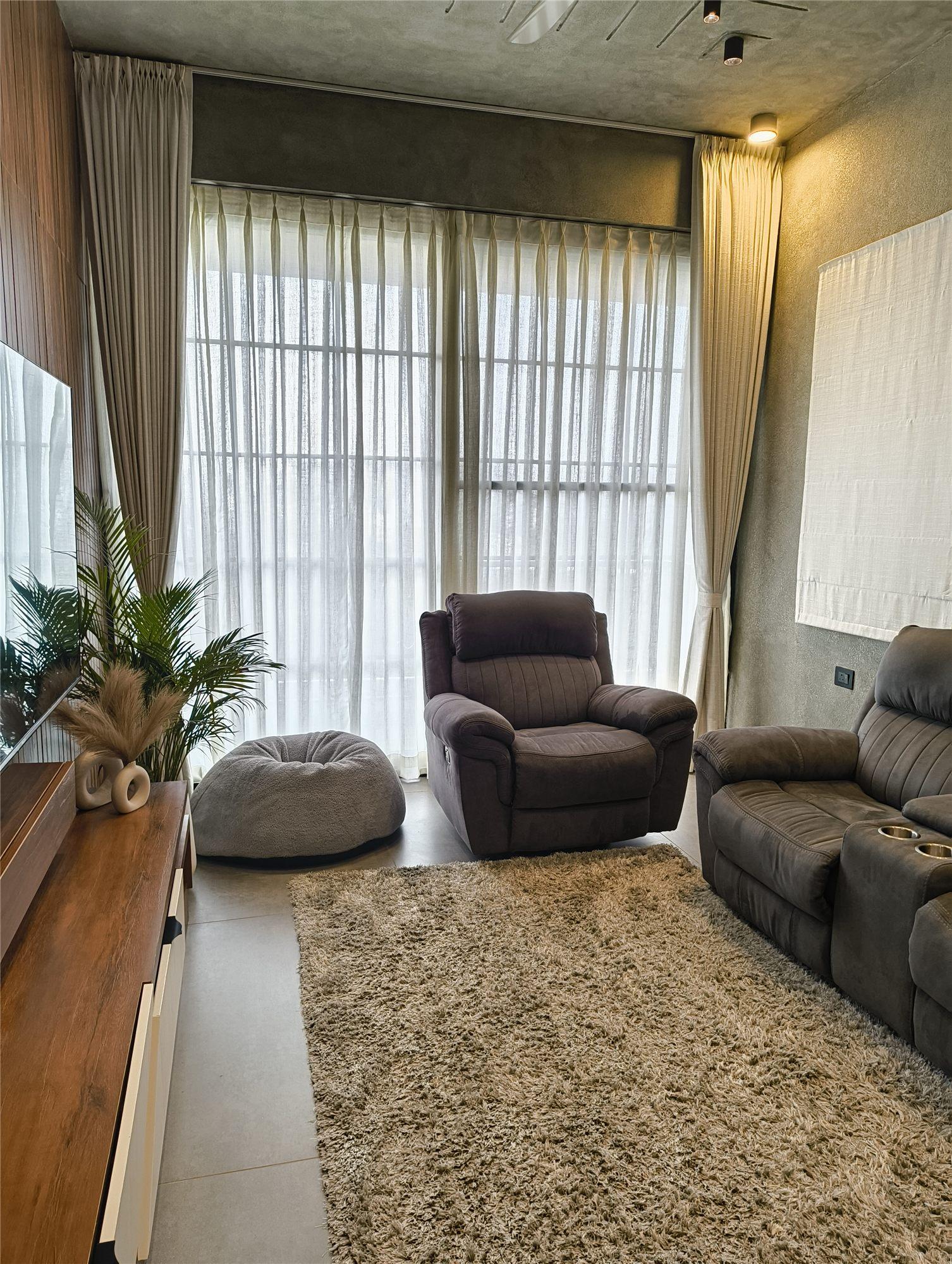 Gubbi Gudu villa, Anjanapura, Bangalore — living room with full-height curtains, large windows and recliners