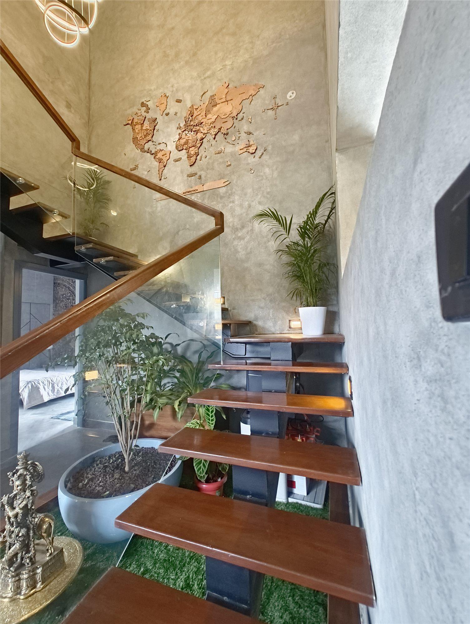 Gubbi Gudu villa, Anjanapura, Bangalore — open-riser staircase with a world-map wall and an indoor garden